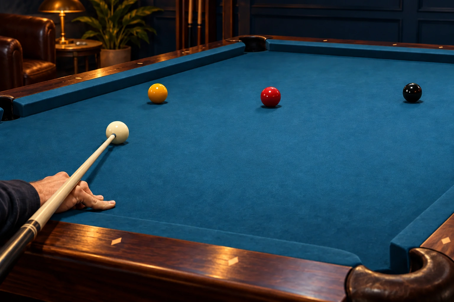 Anonymous hand holding an ordinary cue beside one white cue ball and colored object balls on a clean table