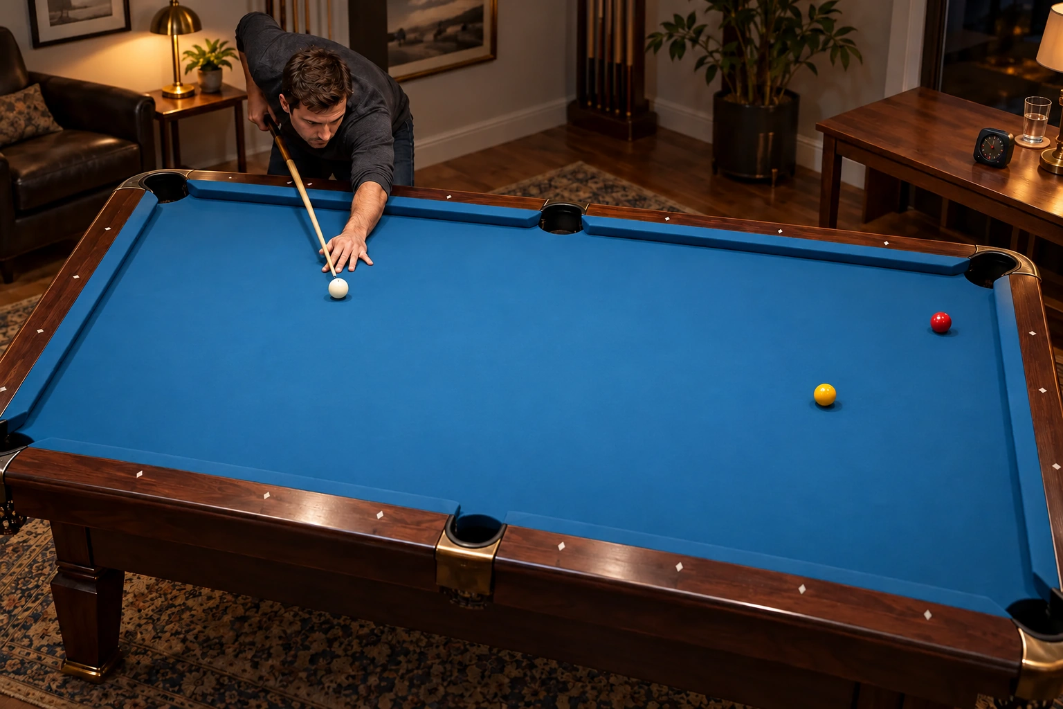 Anonymous player with one white cue ball and two ordinary object balls on an unmarked pool table