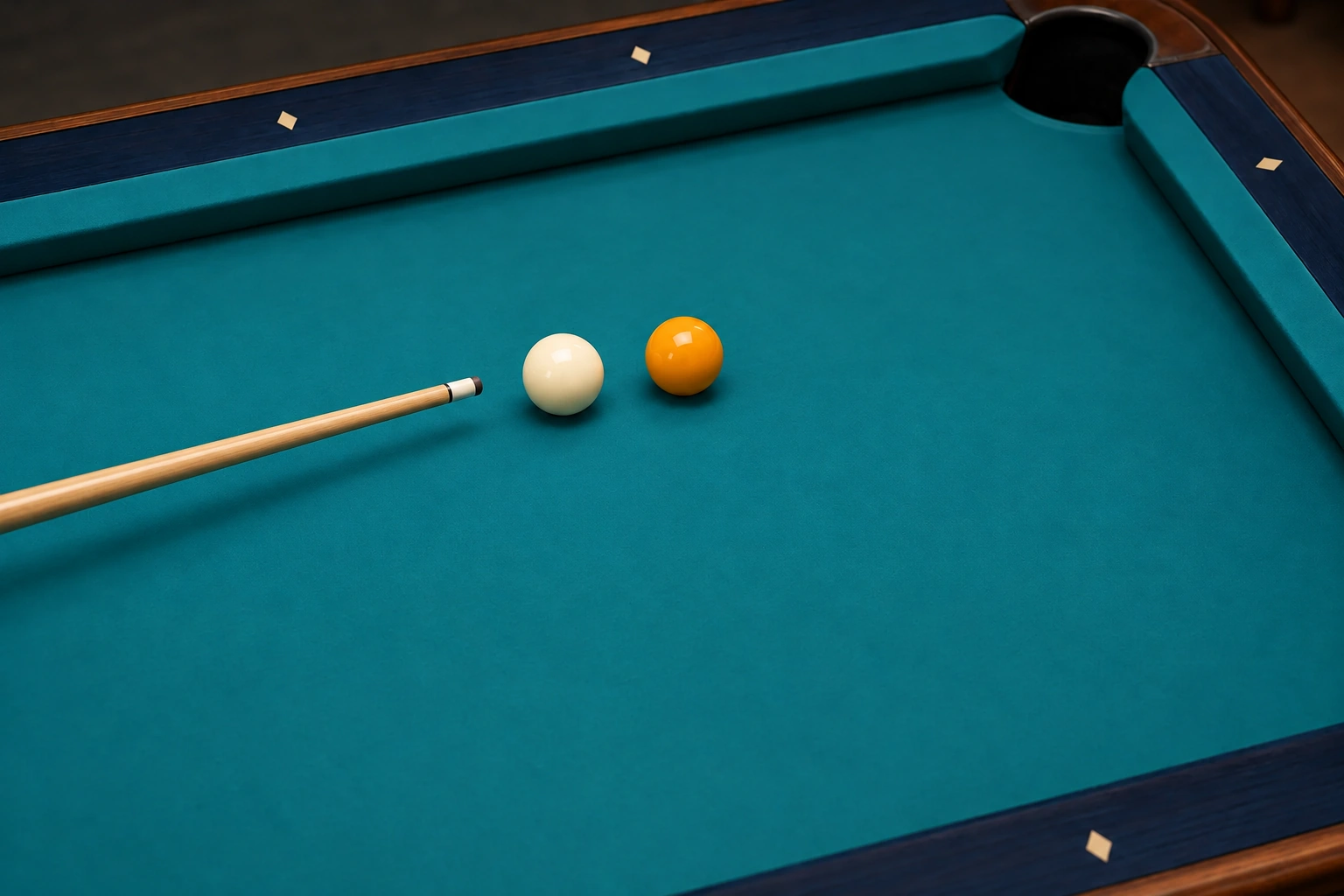 One resting cue ball and one yellow object ball, separated on pool cloth, with the wooden cue tip behind the cue ball and no trajectory traces