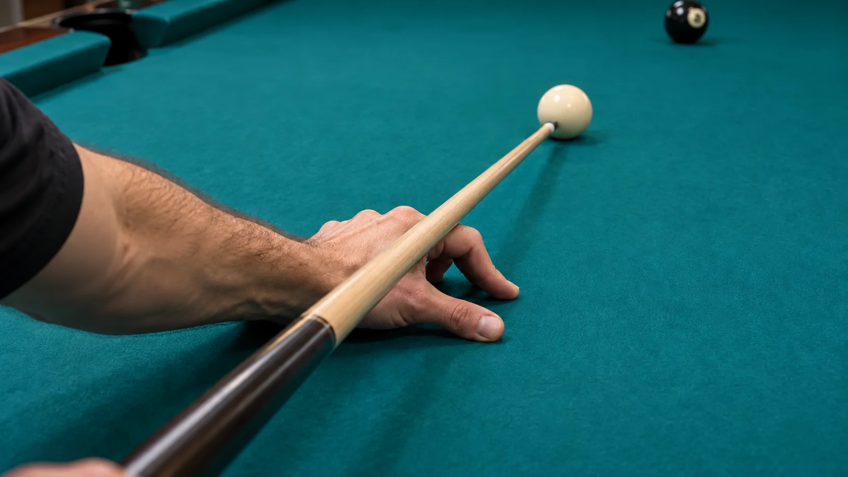 Editorial close-up of a real bridge hand and straight cue without ghost shafts or an inferred grip-wrist measurement