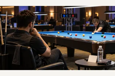Focused pool competitor observing the table between turns during a structured match